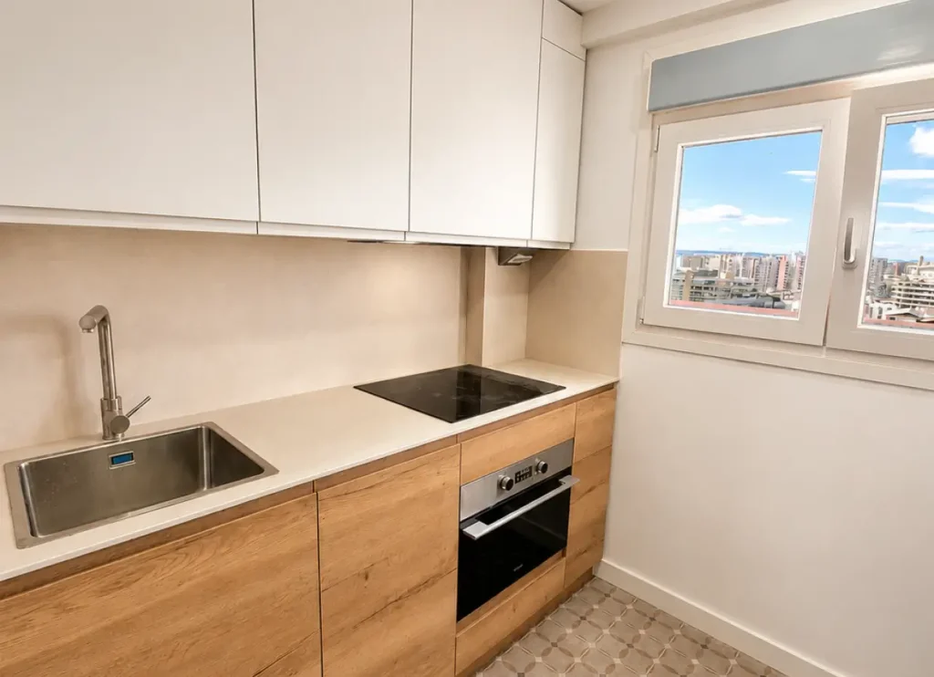 cocina con electrodomésticos en blanco y madera clara